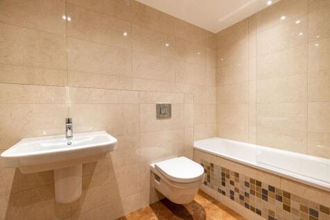 Bright and modern bathroom suite featuring a cl...