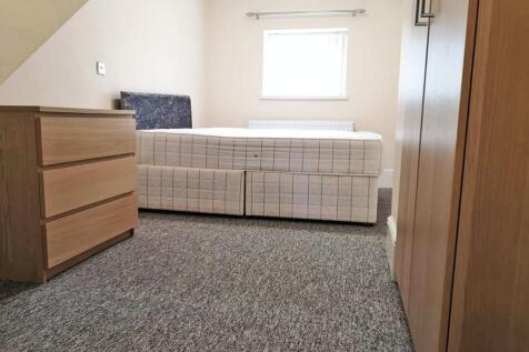 A neat and tidy single bedroom featuring a comf...