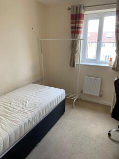A bright single bedroom featuring a comfortable...