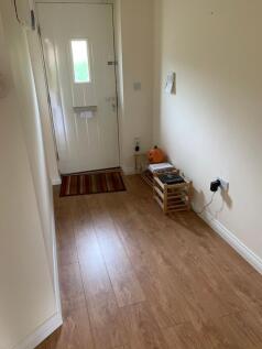 A neat and tidy hallway with light wooden floor...