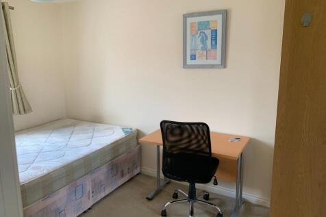 A cozy single bedroom featuring a neatly made b...