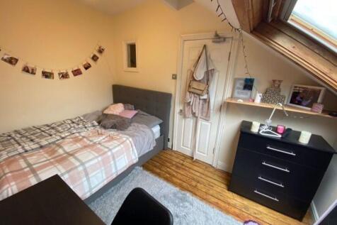 A cozy single bedroom featuring a neatly made s...