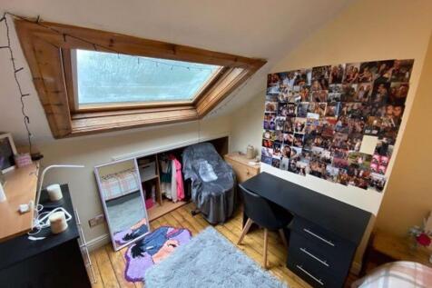 Cozy single bedroom featuring a sloped skylight...