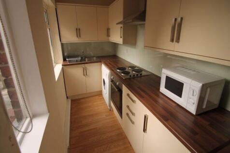 A bright, modern kitchen featuring a clean wood...