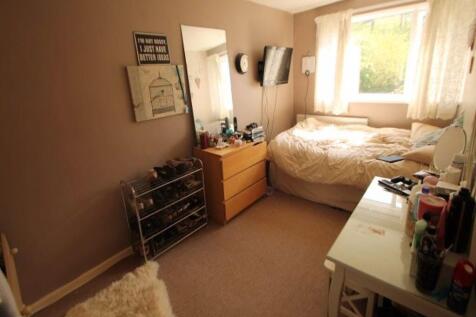 A cozy single bedroom with a comfortable bed by...