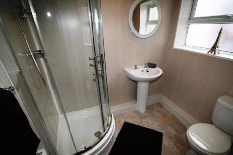 A modern bathroom featuring a curved glass show...