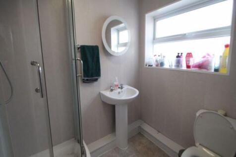 A clean and well-lit bathroom featuring a walk-...