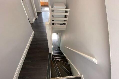 A clean and modern staircase with dark wood flo...