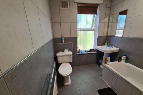 A modern bathroom featuring a white bathtub, pe...