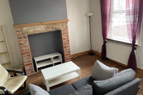 A cozy living room featuring a comfortable grey...