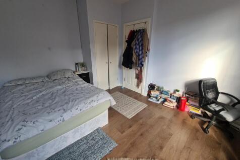 A clean and simple bedroom featuring a comforta...