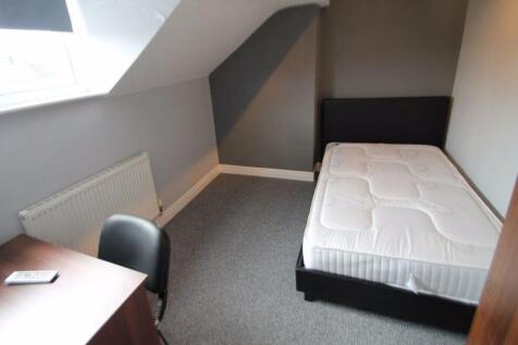 A clean and well-lit single bedroom featuring a...