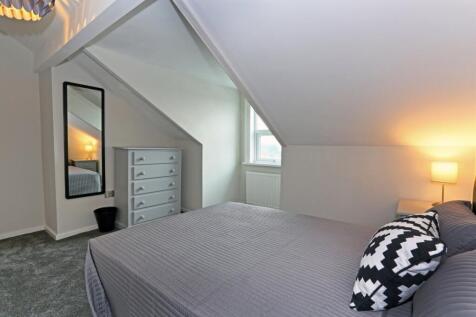 A cozy and well-kept master bedroom featuring a...