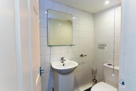 A clean and modern bathroom featuring white til...