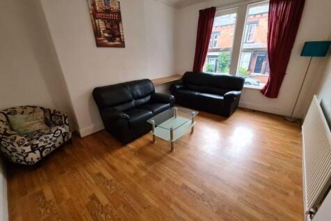 A spacious living room with wooden flooring, tw...