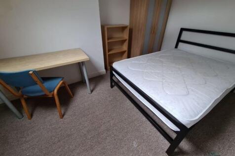 A simple and clean single bedroom featuring a s...