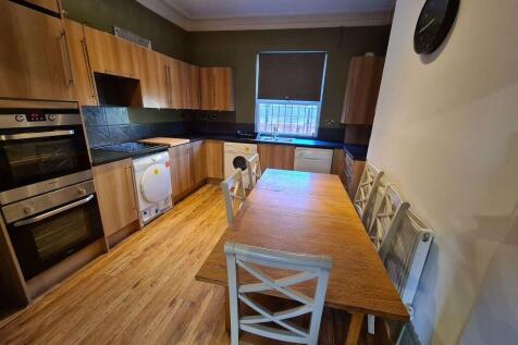 A bright and modern kitchen featuring wooden ca...
