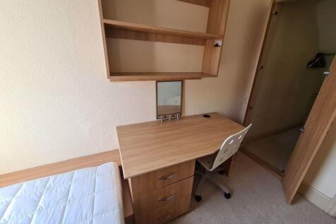 A neat and functional student bedroom featuring...