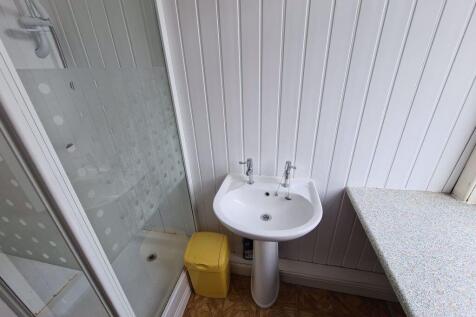 A bright and tidy bathroom featuring a corner s...