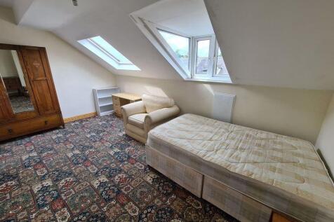 A cozy single bedroom featuring a patterned car...