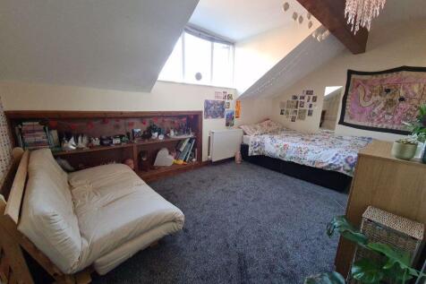 A spacious and inviting attic bedroom featuring...