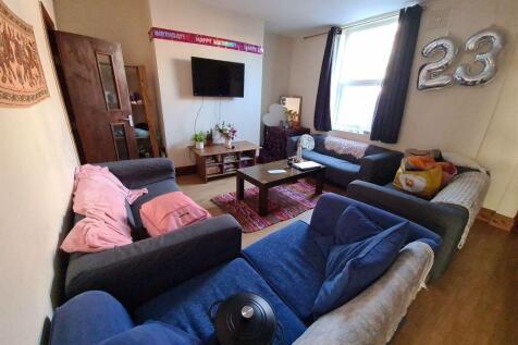 A cozy living room featuring multiple sofas arr...