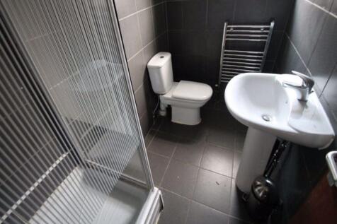 A modern bathroom suite featuring a walk-in sho...