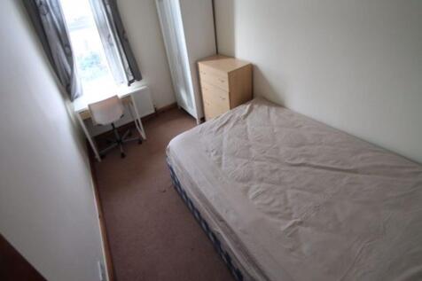 A tidy and well-lit small bedroom with a single...