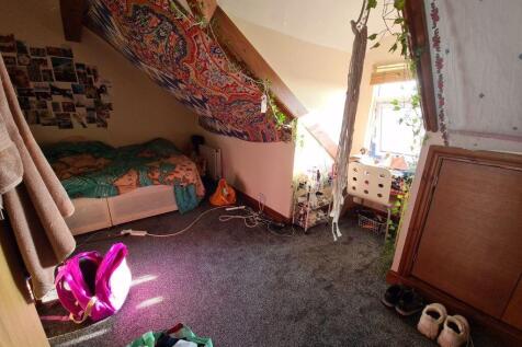 Bright and cozy single bedroom featuring a slop...