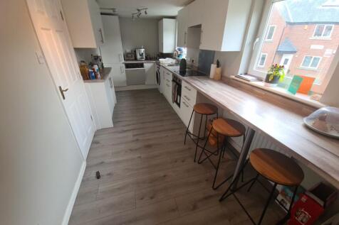 Bright and modern kitchen featuring a long brea...
