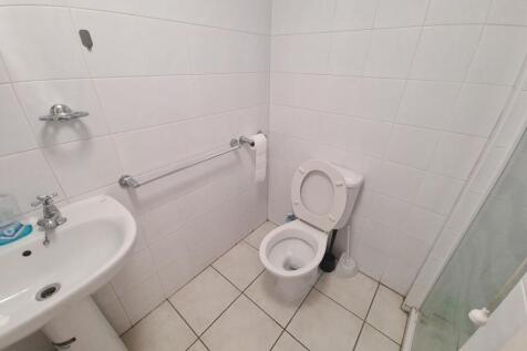A clean and simple single toilet room featuring...