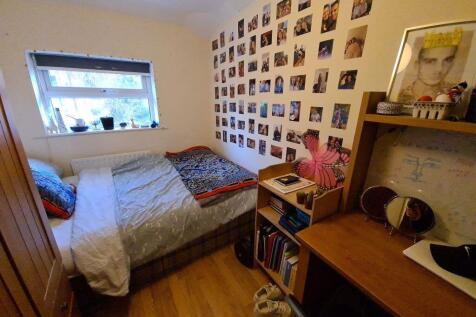 Cozy single bedroom featuring a comfortable bed...