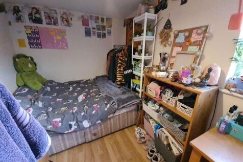 Cozy single bedroom featuring a comfortable bed...