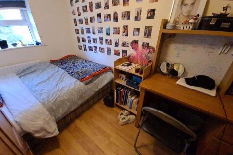 A cozy single bedroom featuring a neatly made b...