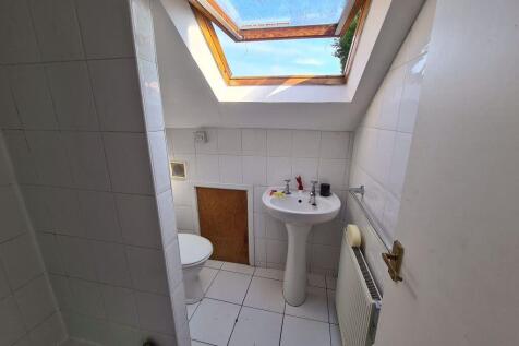 Bright bathroom with white tiled walls and floo...