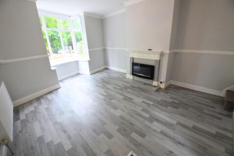 A bright and spacious living room with light gr...