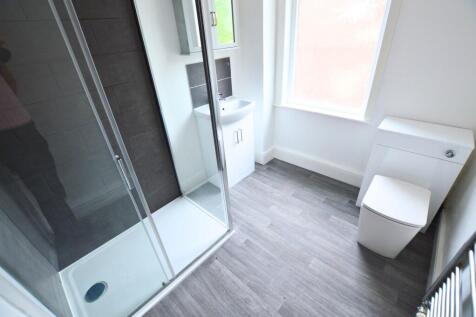 A modern bathroom featuring a spacious shower e...