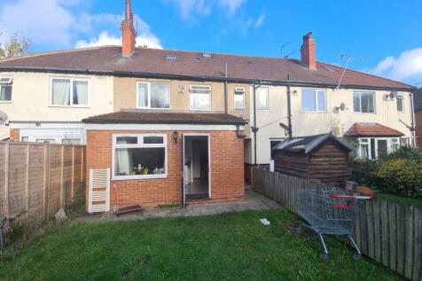 A spacious and well-maintained garden area behi...