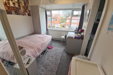 A cozy single bedroom featuring a comfortable b...