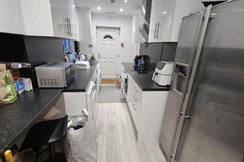 A modern, well-equipped kitchen with sleek whit...