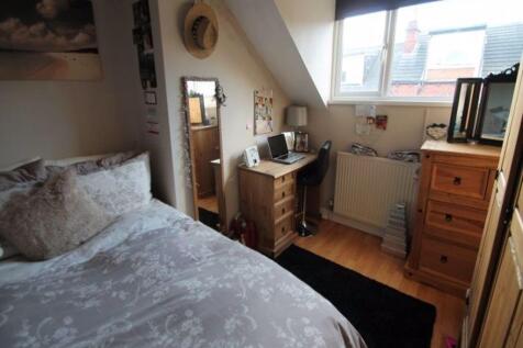 A cozy single bedroom featuring a comfortable b...