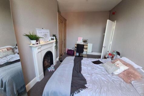 A spacious and cozy master bedroom featuring a ...