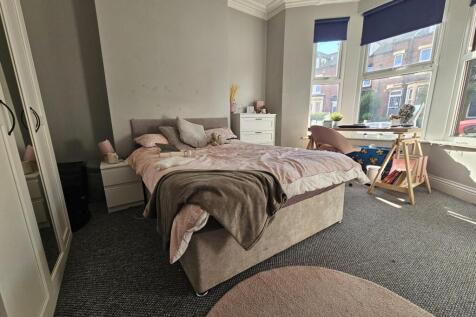 A cozy and stylish master bedroom featuring a c...