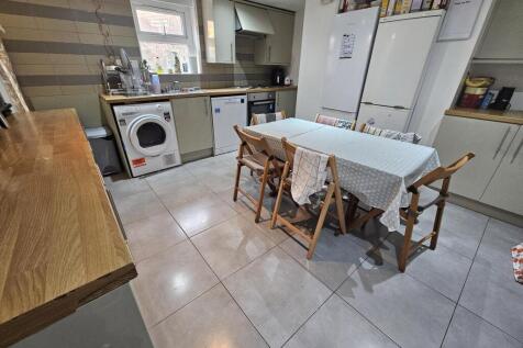 A bright, modern kitchen featuring a clean tile...
