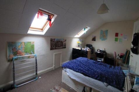 A cozy attic master bedroom featuring angled sk...