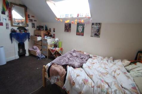A cozy double bedroom with sloped ceilings and ...