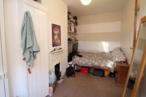 Cozy single bedroom featuring a single bed tuck...