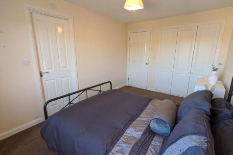 A cozy double bedroom featuring a stylish black...