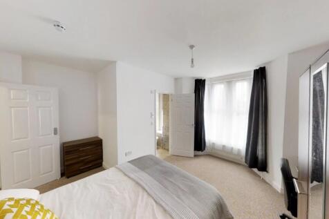 Spacious double bedroom featuring large windows...