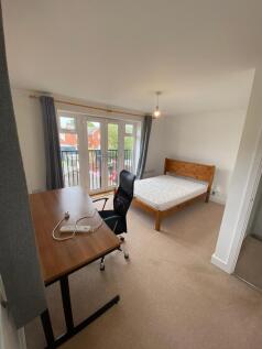This bright and airy double bedroom features a ...